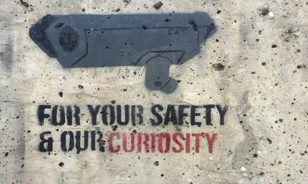 Foto de câmera com escrita "Para sua segurança e nossa curiosidade"